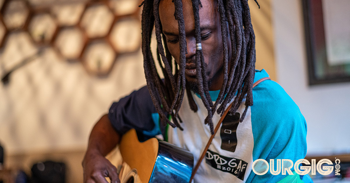 musician with dreads playing guitar