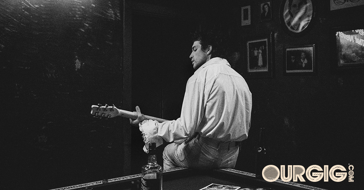 guitar player sitting on pool table