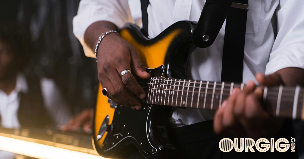 well dressed man playing guitar