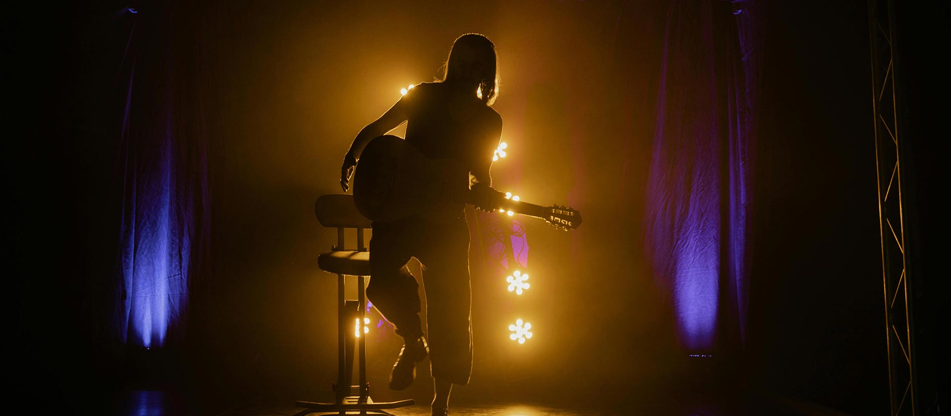 musician on stage under golden lights