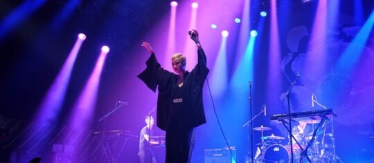 woman performing with band on stage