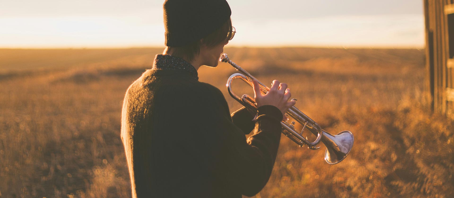 man playing trumpet in an empty field