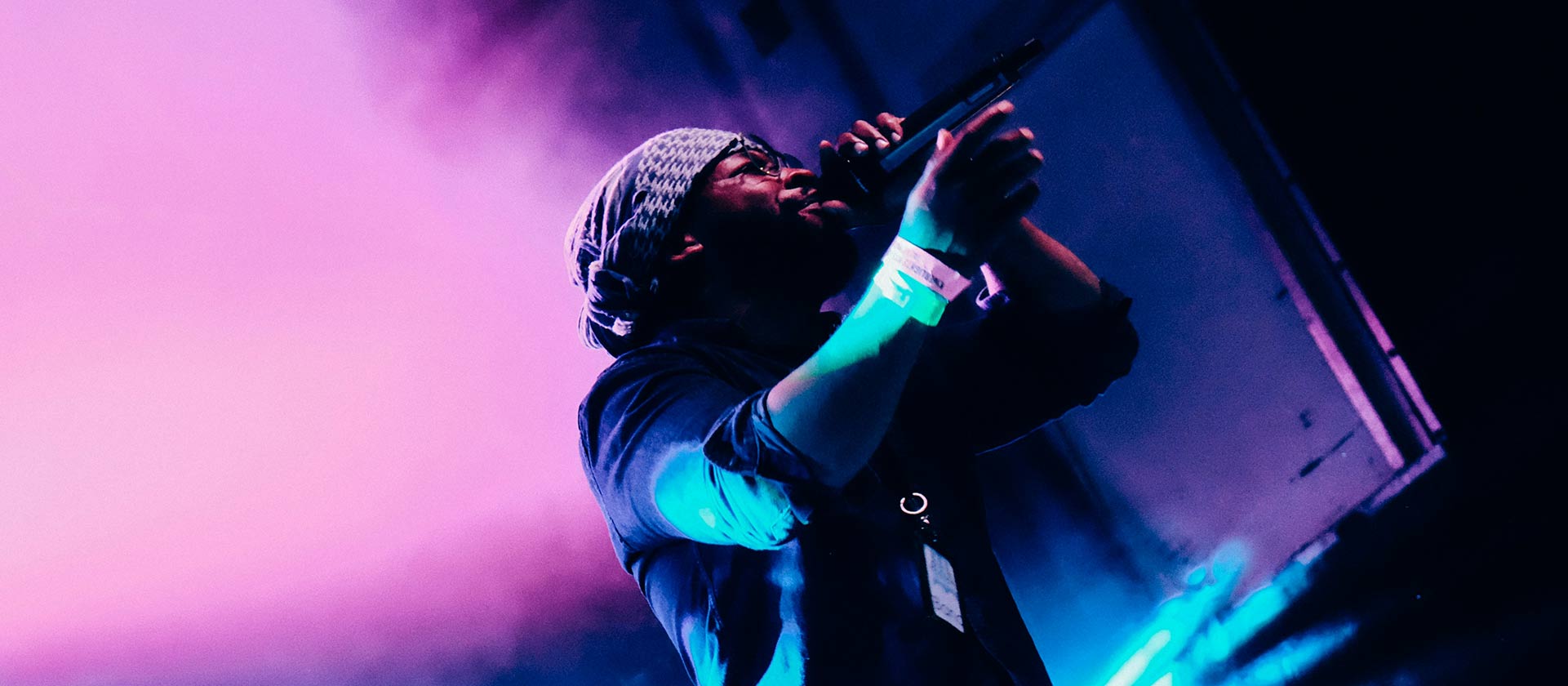 male artist performing on colorfully lit state