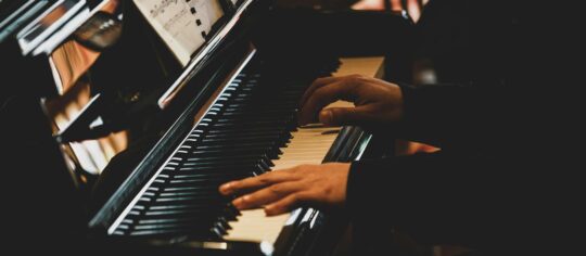 piano players hands on keyboard