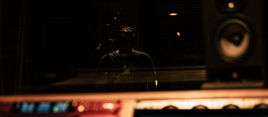 photo of recording studio with male vocalist in the vocal room
