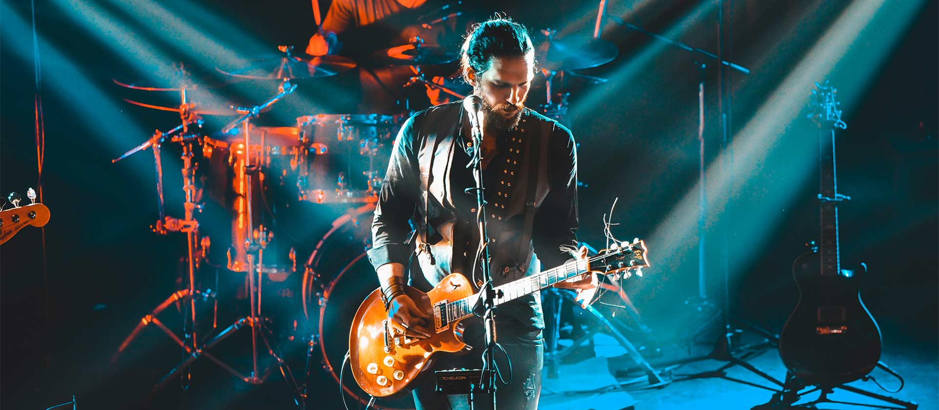 male artist playing guitar in concert