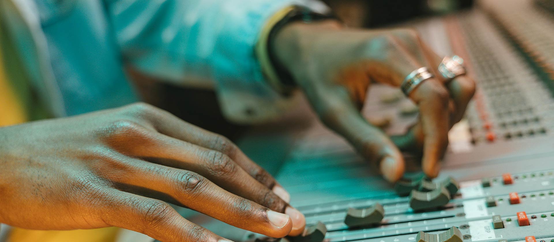 mans hands at studio mixing board
