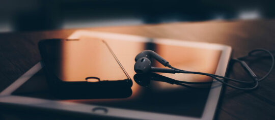 cell phone with earbuds and ipad