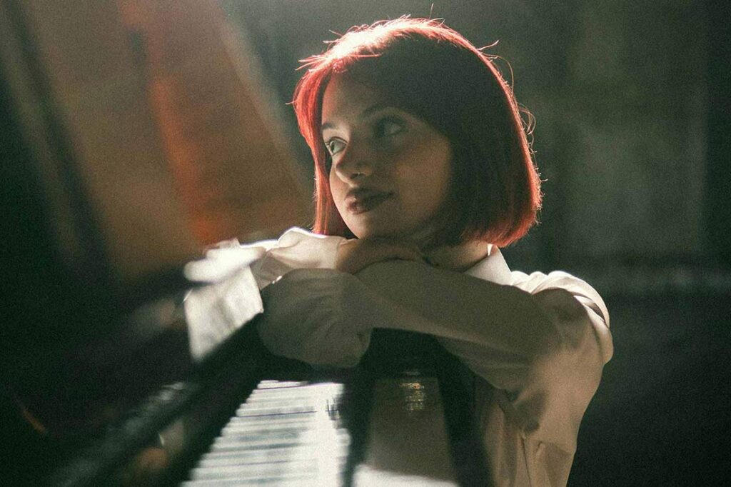 female artist posing at piano