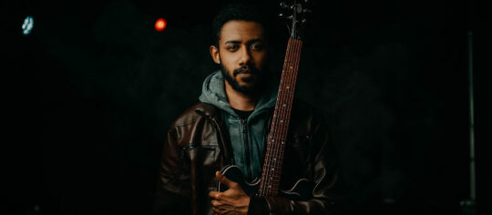 musician holding guitar on stage