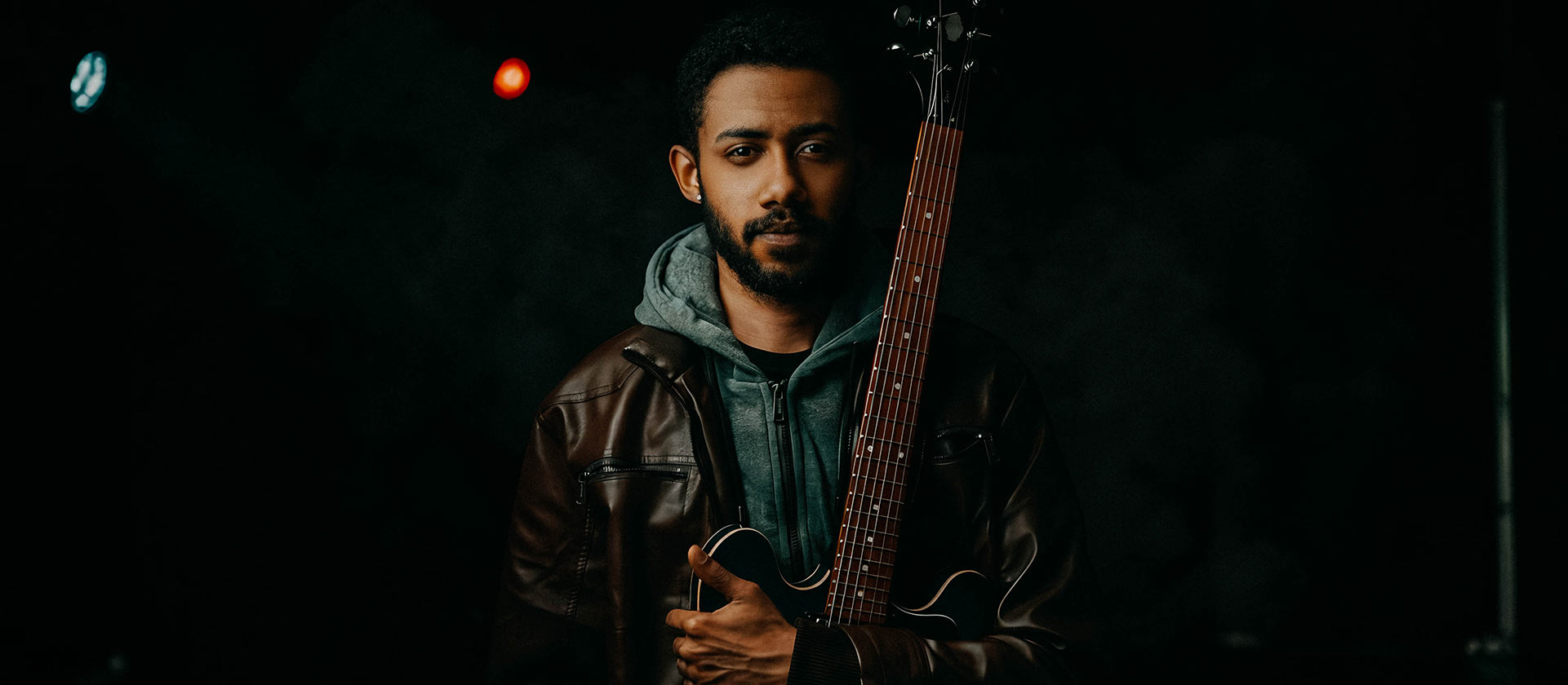 musician holding guitar on stage