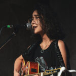 female singer songwriter playing guitar