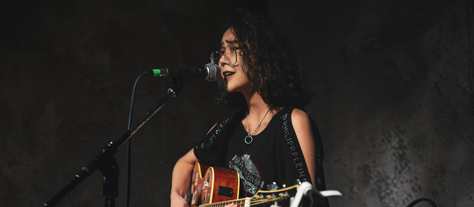 female singer songwriter playing guitar