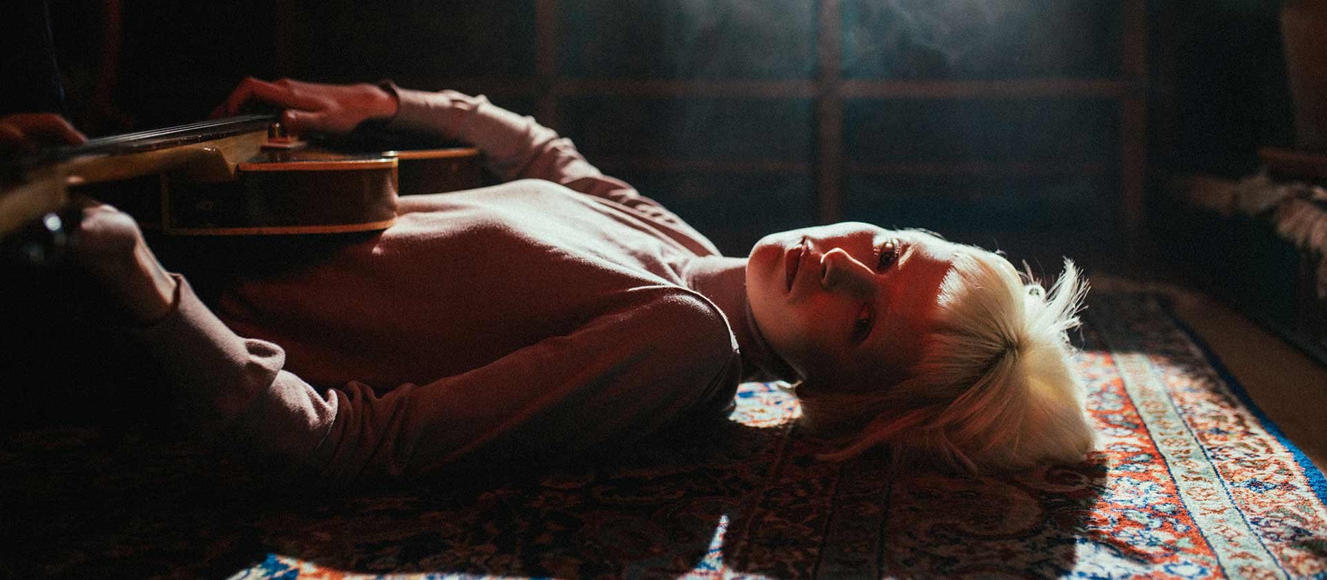 woman on floor holding guitar